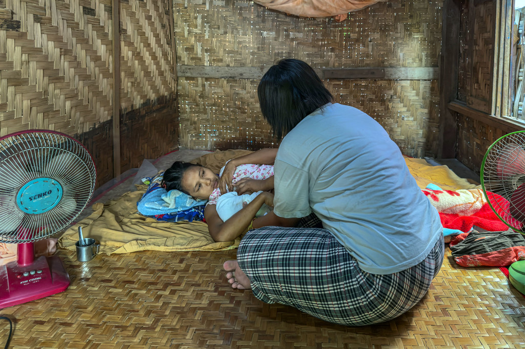 Yu Yu, a midwife, provides care for a newborn baby and the mother after her delivery in an emergency.